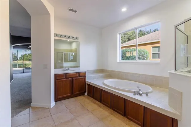 a spacious bathroom with a granite countertop tub sink and mirror