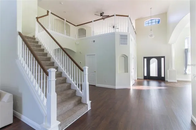 a view of staircase with white walls and wooden floor