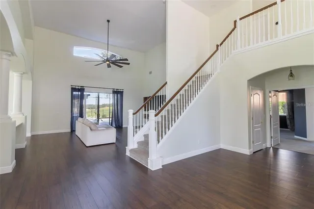 a view of a livingroom with wooden floor and stairs
