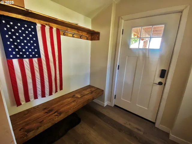 a view of a hallway with wooden floor and stairs
