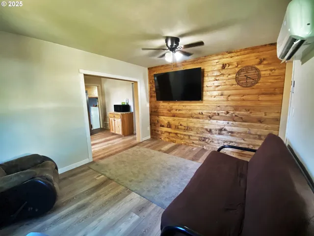 a view of a livingroom with wooden floor and a ceiling fan
