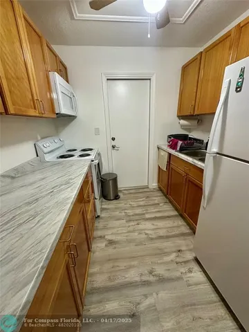 a kitchen with a sink a refrigerator and cabinets
