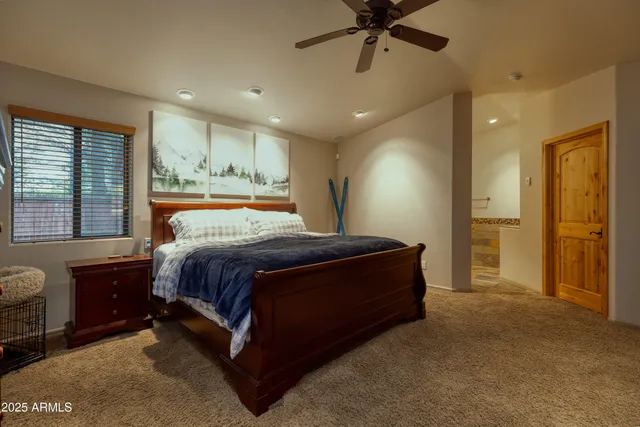 a spacious bedroom with a large bed and a chandelier