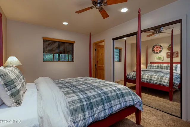 a bedroom with a bed a dresser and painting