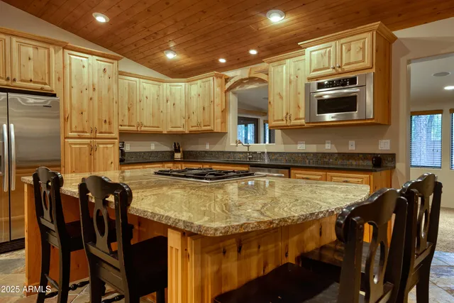 a kitchen with kitchen island a counter top space cabinets stainless steel appliances and a window