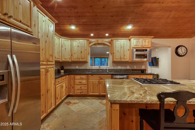 a kitchen with stainless steel appliances granite countertop a sink a stove and a refrigerator