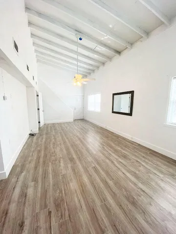 a view of empty room with wooden floor