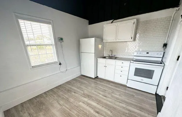 a kitchen with white cabinets and white appliances