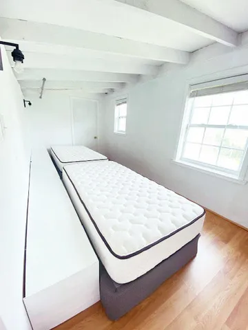 a bed sitting in a bedroom next to a window