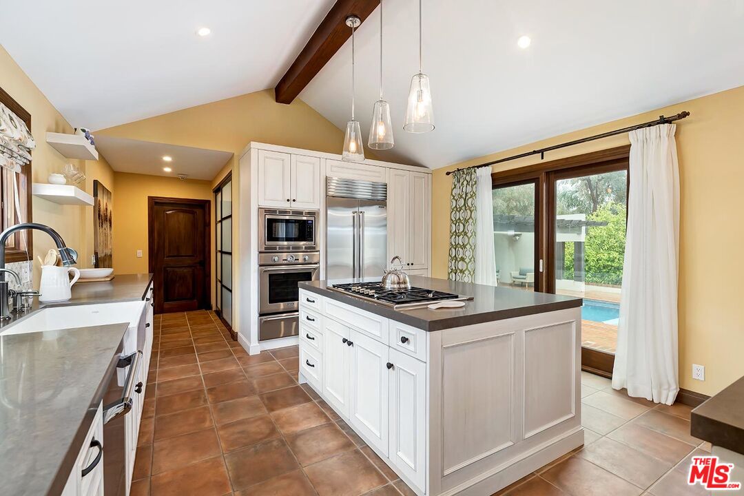 13146 Rivers Road Los Angeles, CA 90049 - Photo 12 of 38 a kitchen with stainless steel appliances granite countertop a stove and a sink