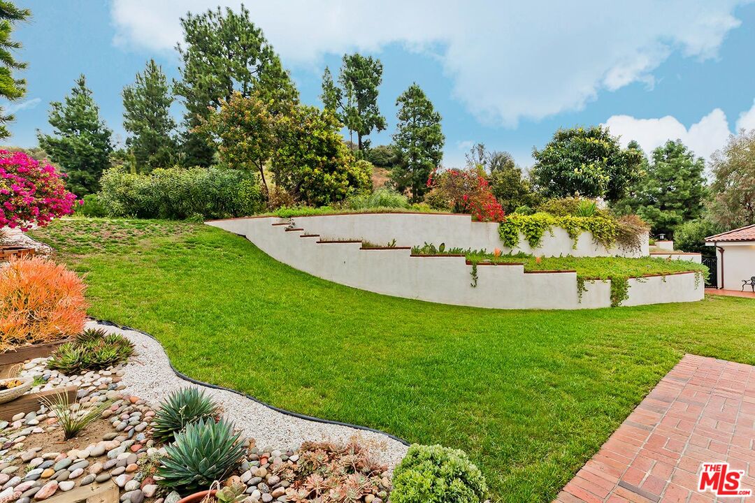 13146 Rivers Road Los Angeles, CA 90049 - Photo 26 of 38 a view of a swimming pool with a garden