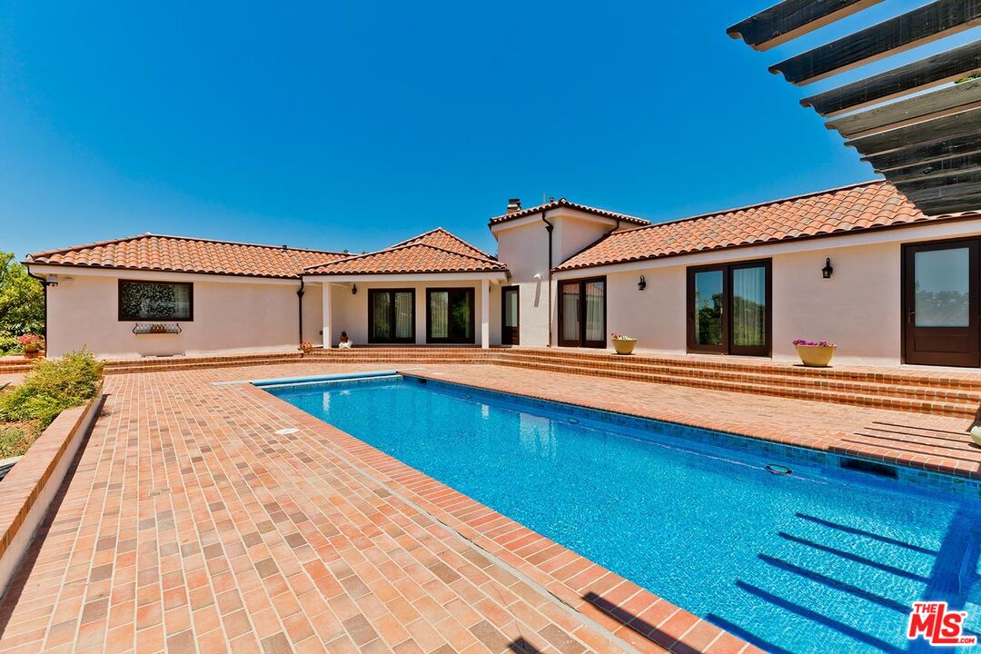 13146 Rivers Road Los Angeles, CA 90049 - Photo 37 of 38 a house with swimming pool in front of it