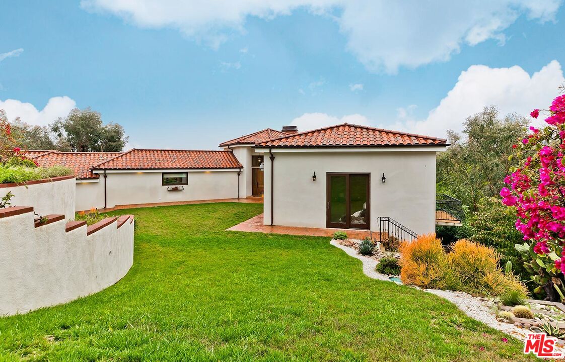 13146 Rivers Road Los Angeles, CA 90049 - Photo 6 of 38 a front view of a house with a yard and porch