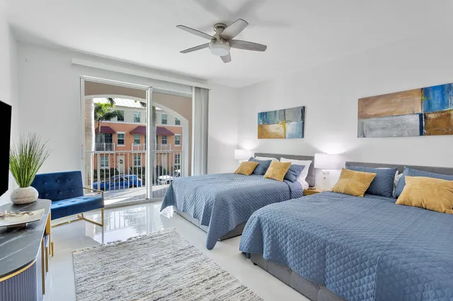 a bedroom with two beds and a potted plant