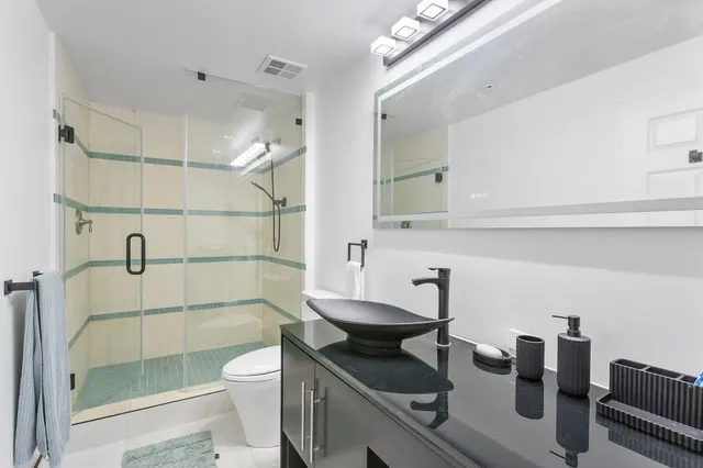 a bathroom with a sink a toilet and shower