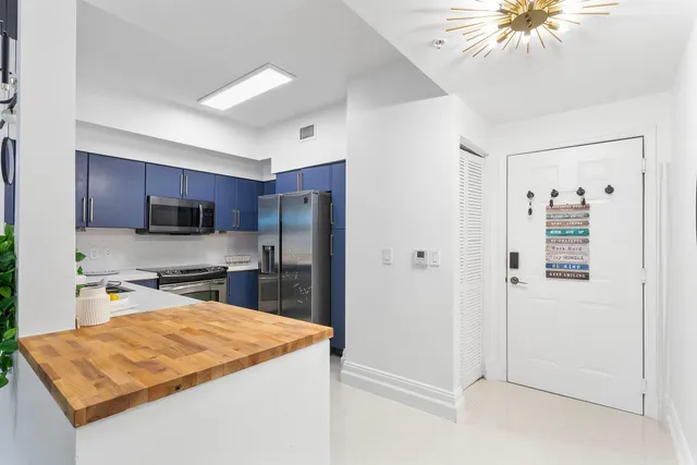 a kitchen with stainless steel appliances granite countertop a refrigerator a sink dishwasher a stove with white cabinets and granite countertops