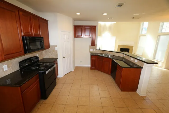 a kitchen with stainless steel appliances granite countertop a stove a sink and a microwave