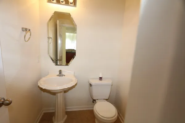 a bathroom with a toilet sink and mirror