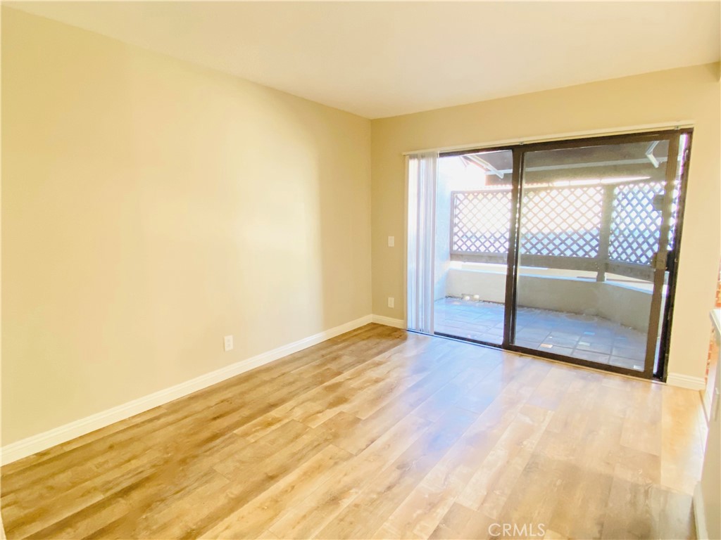 30 Mountain Shadows Place Pomona, CA 91766 - Photo 7 of 23 an empty room with wooden floor and door