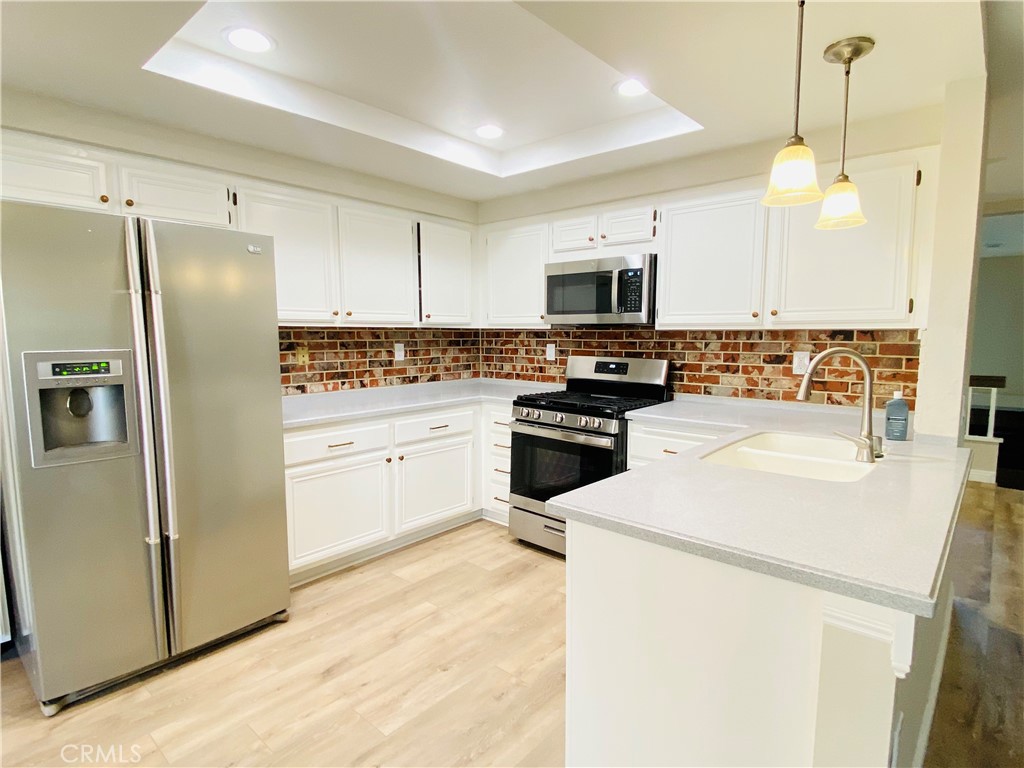 30 Mountain Shadows Place Pomona, CA 91766 - Photo 9 of 23 a kitchen with a refrigerator a stove top oven a sink and cabinets
