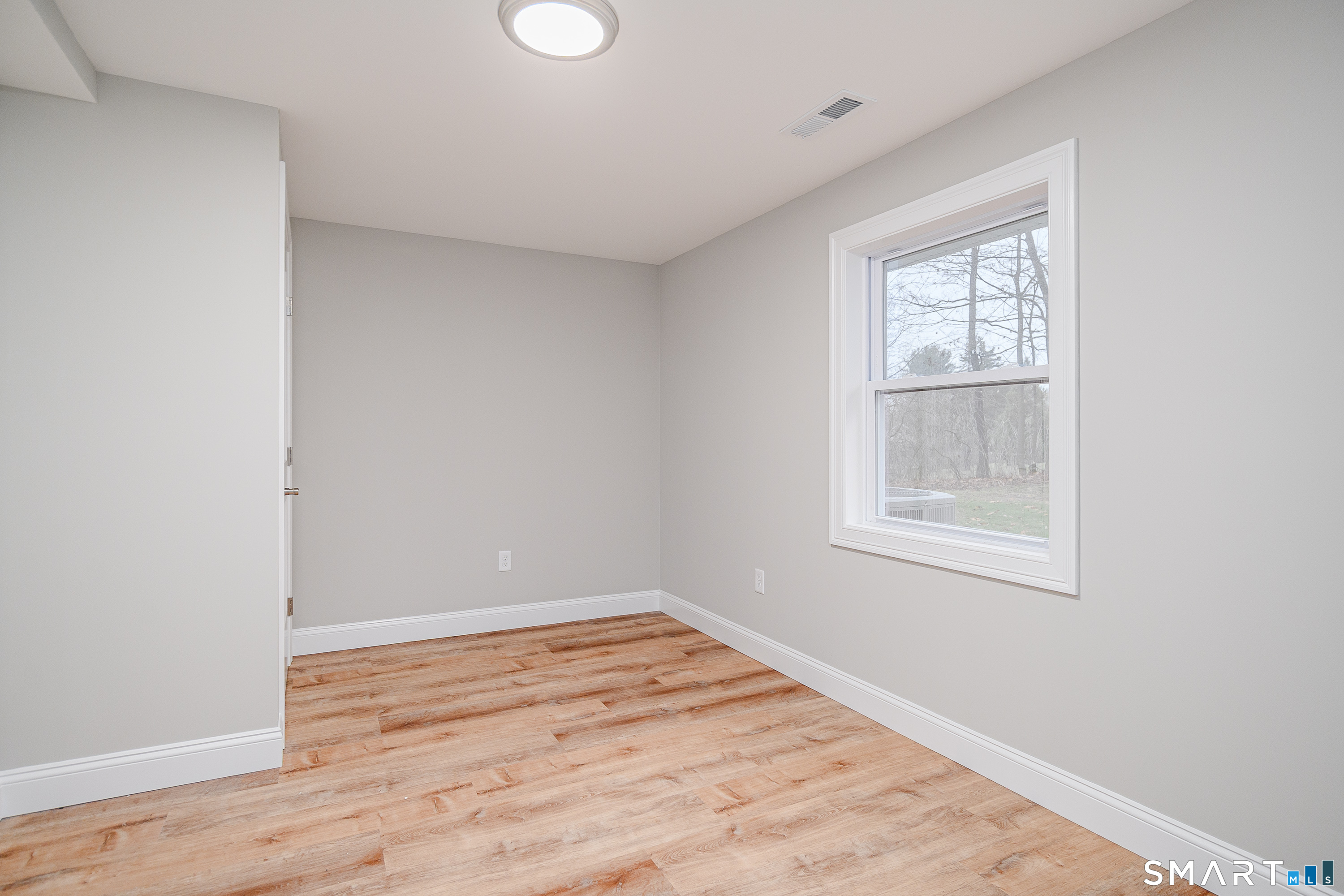 284 Chestnut Tree Hill Road Oxford, CT 06478 - Photo 17 of 34 an empty room with wooden floor and windows