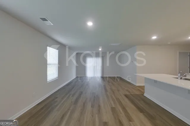 a large white kitchen with kitchen island a sink a stove and a refrigerator