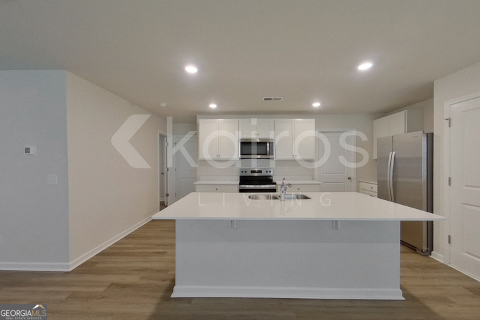 109 Inez Avenue Springfield, GA 31329 - Photo 5 of 26 a large white kitchen with kitchen island a sink a stove and a refrigerator