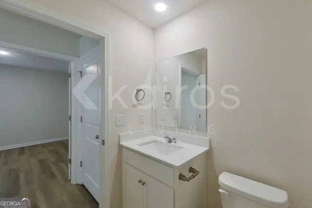 an empty room with wooden floor and mirror