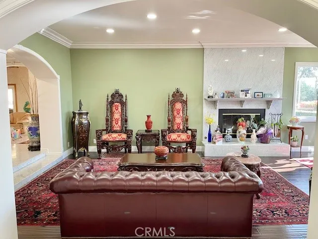 a living room with furniture a fireplace and chandelier