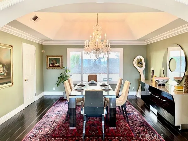 a view of a dining room with furniture a chandelier and wooden floor