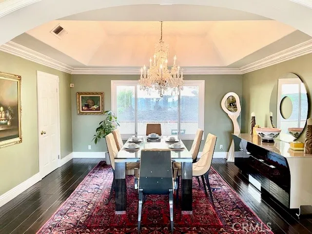 a view of a dining room with furniture a chandelier and wooden floor