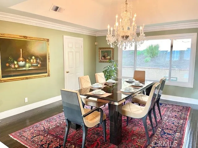 a dining room with furniture a large window and a chandelier