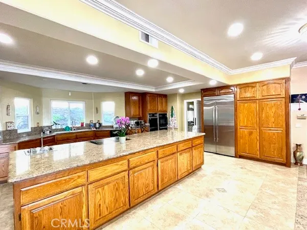 a large kitchen with stainless steel appliances granite countertop a sink and cabinets