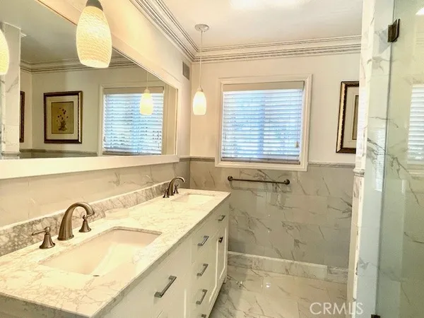 a bathroom with a granite countertop sink a mirror and a shower
