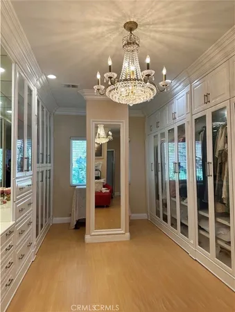 a view of a livingroom with a chandelier fan and windows
