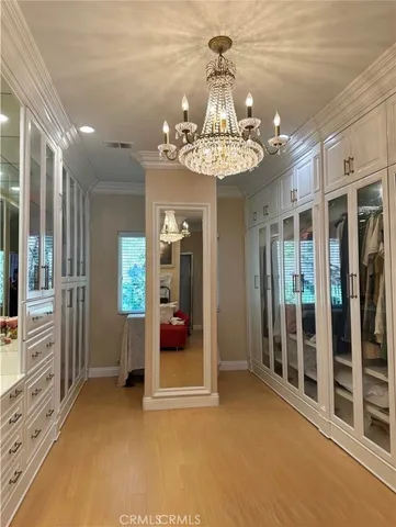 a view of a livingroom with a chandelier fan and windows