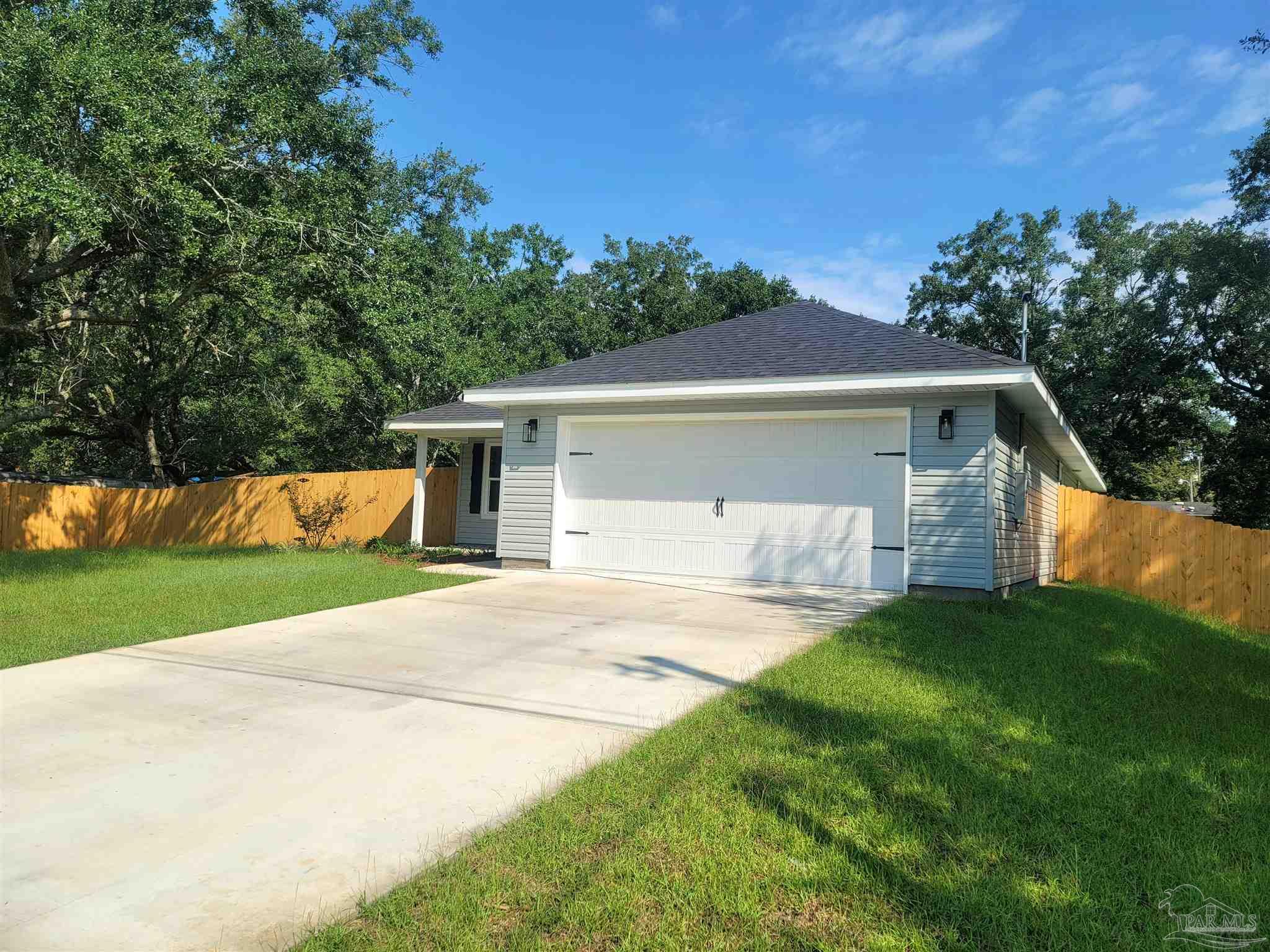 3030 Ferris Drive Navarre, FL 32566 - Photo 2 of 40 a front view of a house with a yard and garage