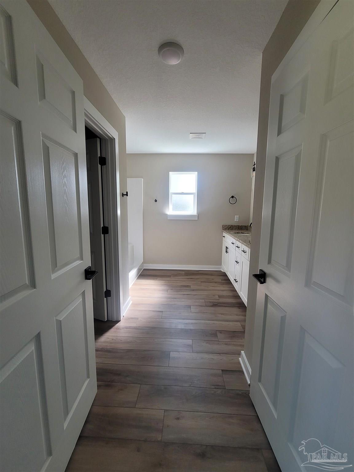3030 Ferris Drive Navarre, FL 32566 - Photo 32 of 40 a view of a hallway with wooden floor and staircase
