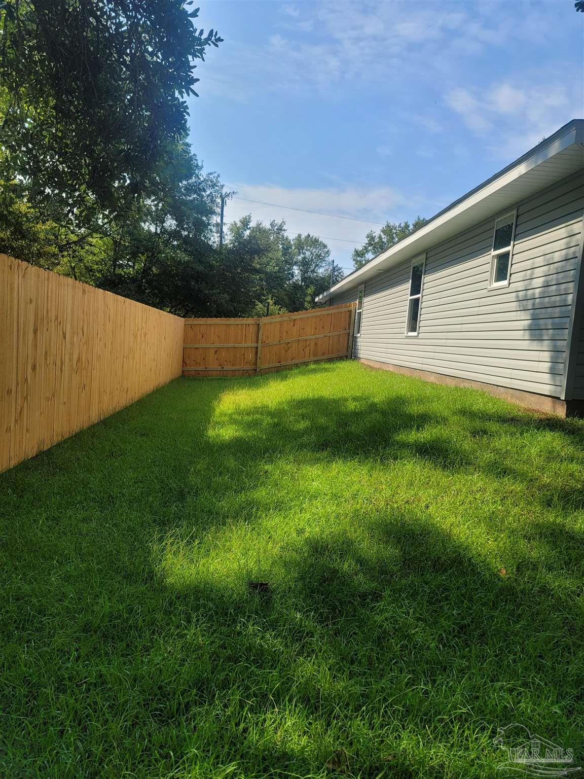 3030 Ferris Drive Navarre, FL 32566 - Photo 8 of 40 a backyard of a house with lots of green space