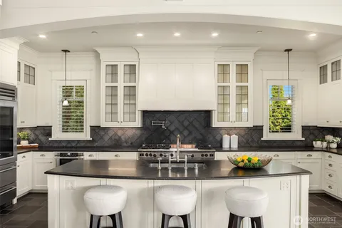 a kitchen with granite countertop a sink and chairs