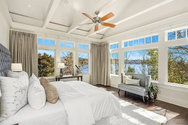 a bedroom with a bed and a large window with balcony view