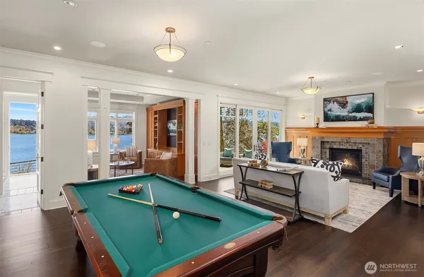 a living room with furniture pool table and a fireplace