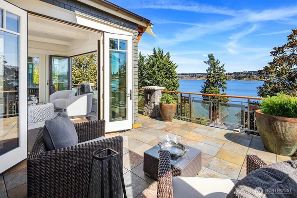 a view of a patio with couches chairs potted plants and floor to ceiling window