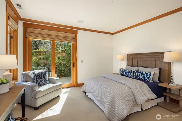 a bedroom with a bed couch and a large window