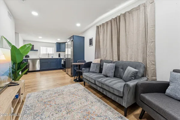 a living room with furniture kitchen and a large window