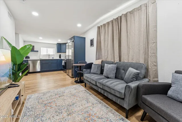 a living room with furniture kitchen and a large window