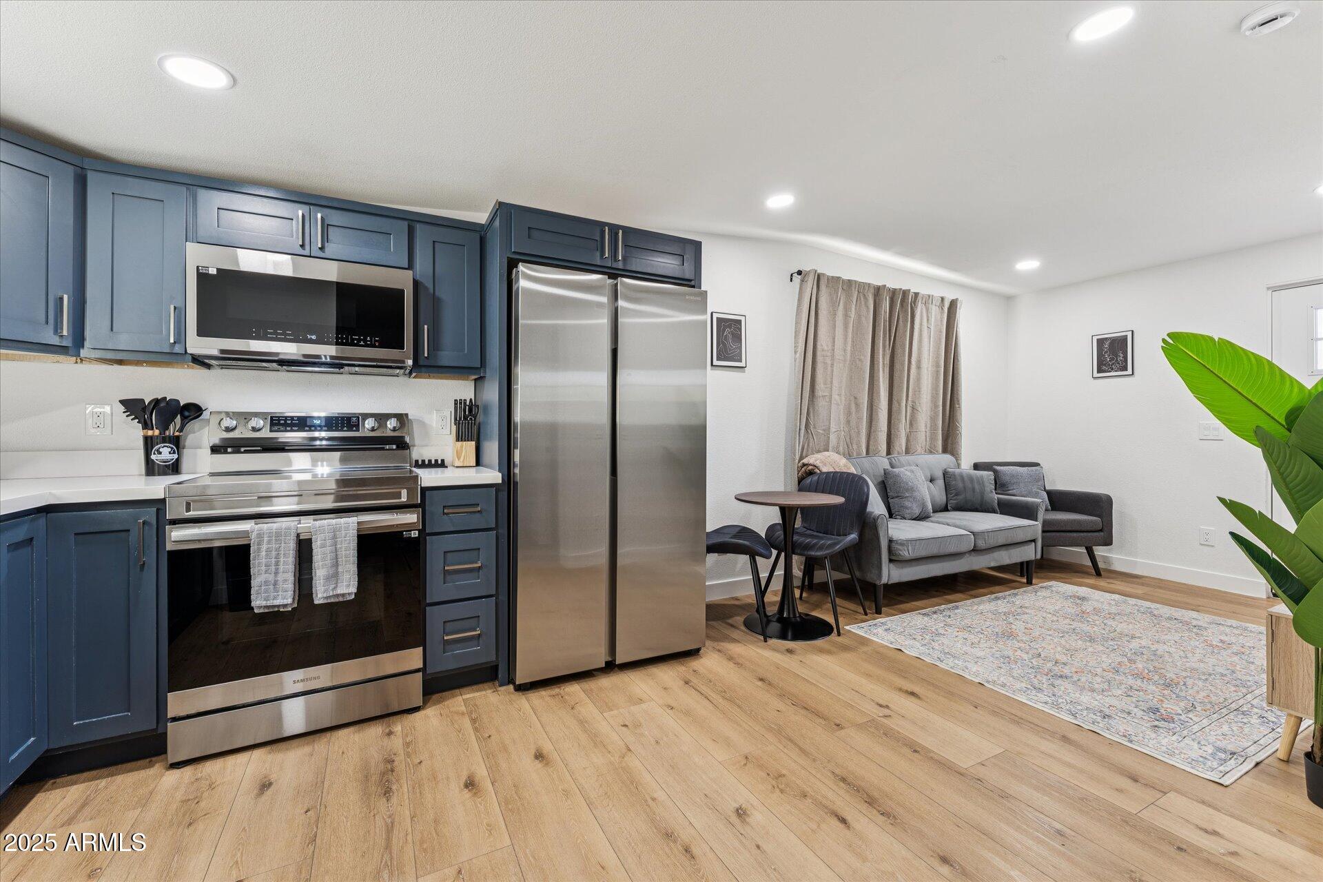 1548 North Upland Circle, Unit B Mesa, AZ 85201 - Photo 4 of 18 a kitchen with stainless steel appliances a stove a microwave and a refrigerator