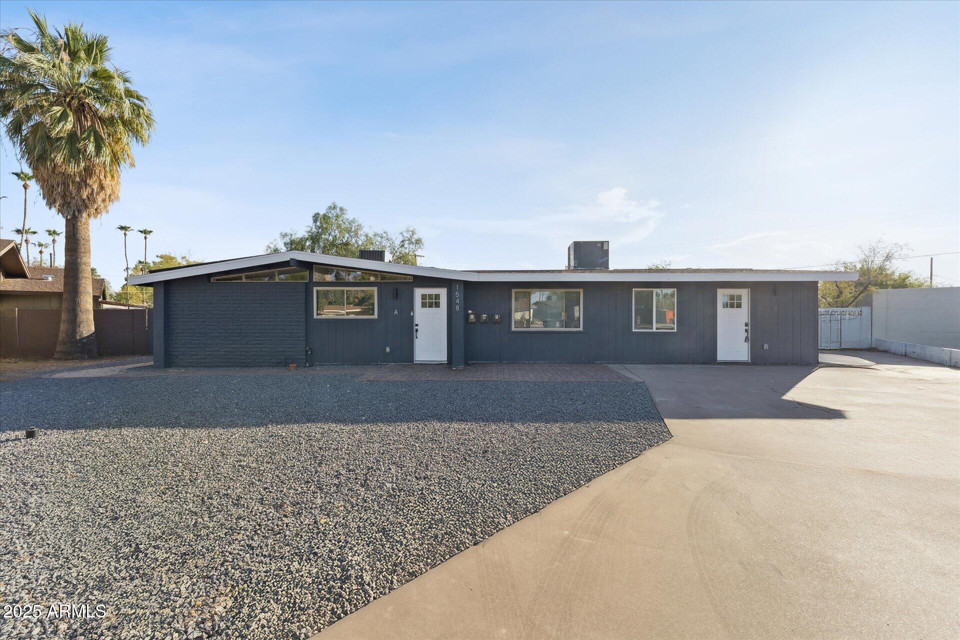 1548 North Upland Circle, Unit B Mesa, AZ 85201 - Photo 5 of 18 a front view of a house with a yard and a garage