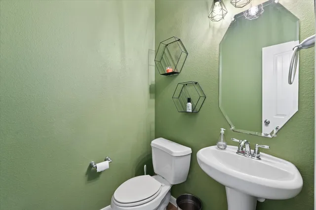 a bathroom with a toilet sink and mirror