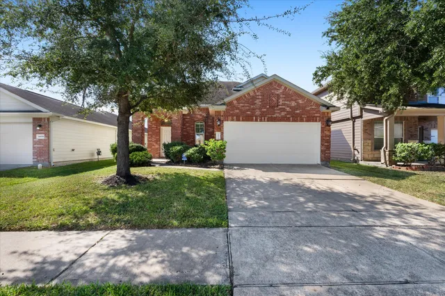 a front view of a house with a garden and trees